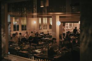 シドニーにあるParamount House Hotelのレストランのテーブルに座っている人々のグループ +2枚の写真