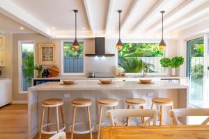 a kitchen with a large island with bar stools at Capri Beach House in Shoal Bay +42 photos