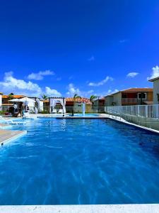 a large swimming pool with blue water at Ap 2 quartos tipo resort pé na areia 1 in Barra dos Coqueiros