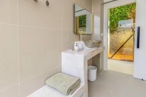 a white bathroom with a sink and a mirror at Mountain Skyline Glass House V1 Doi Sakad, Nan in Ban Sakat Nua