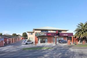 a building on a street with a car parked in front at Accommodation Gateway Motel in Palmerston North
