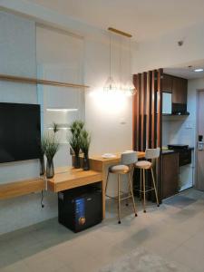 Il comprend un salon avec une cuisine équipée d'une table et de chaises. dans l'établissement Hill Residences by Casa Stellar, à Manille