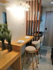 une cuisine avec une table et des chaises en bois dans l'établissement Hill Residences by Casa Stellar, à Manille 3 autres photos