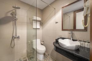 Un baño con inodoro, lavabo y espejo. en Platinum Orchid Hotel Danang, en Da Nang 50 fotos más