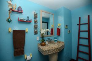 a blue bathroom with a sink and a mirror at Kalani Hawaii Private Lodging in Pupukea +127 photos