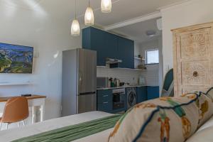 a room with a bed and a kitchen with blue cabinets at Comfort Zone Suites - Hidas in Windhoek +11 photos