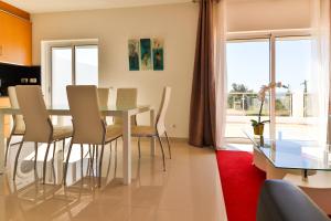a dining room and living room with a table and chairs at Villa Fuseta 102 T in Fuzeta
