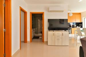 a living room with a television and a kitchen at Villa Fuseta 102 T in Fuzeta