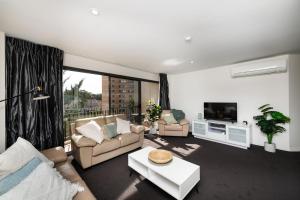 Una sala de estar con dos sofás y un televisor. en Griffin Apartments Kingston ACT, en Canberra
