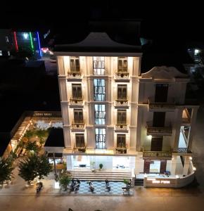 a large white building with lights on it at night at BÌNH MINH HOTEL - ĐẢO PHÚ QUÝ in Cu Lao Thu