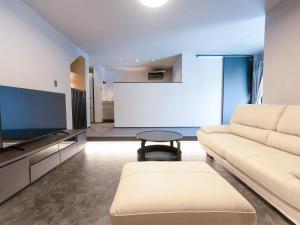 a living room with a couch and a flat screen tv at IZUMO DOGS by HIYORISTAY in Izumo