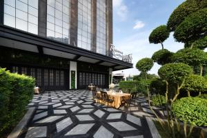 Qingbaijiang成都安兰顿国际酒店的建筑物前有桌椅的露台