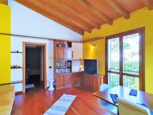 a living room with a table and a tv at Apartment in Bosco with Scenic Terrace in Montegrino Valtravaglia
