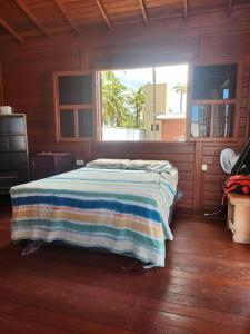 ein Schlafzimmer mit einem Bett, auf dem eine gestreifte Decke liegt in der Unterkunft Vila do Rico in São Gonçalo do Amarante