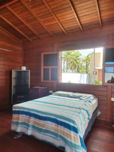ein Schlafzimmer mit einem Bett und einem großen Fenster in der Unterkunft Vila do Rico in São Gonçalo do Amarante