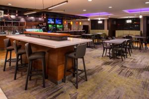 een bar met tafels en stoelen in een restaurant bij Courtyard by Marriott Victorville Hesperia in Hesperia