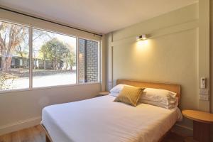 a bedroom with a bed and a large window at Alpine Inn in Khancoban