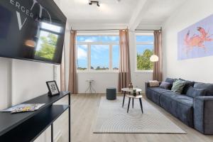 ein Wohnzimmer mit Couch und Tisch in der Unterkunft LINDENLOFT - Modernes Apartment am Lindenbogen in Oldenburg