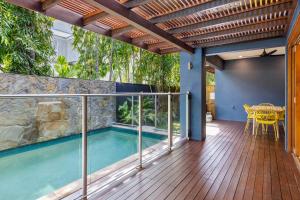 an outdoor deck with a swimming pool and a table at The Savannah Villa in Port Douglas