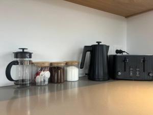 a kitchen counter with jars and a coffee maker at Alpine Chalet - views, fire-pit, central, cosy in Wanaka