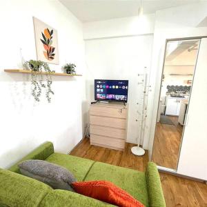 a living room with a green couch and a television at Casa Tosa Podomoro Golf View in Tjikuda Tiga