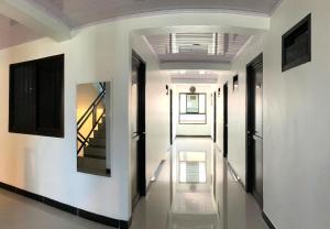 a hallway of a house with white walls and stairs at Kusuma Raya Guest House in Srondolwetan