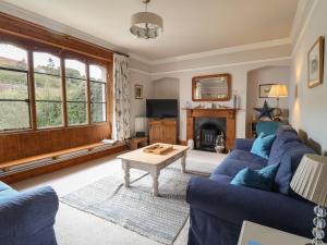 a living room with blue couches and a table at 5 Belmont Terrace in Beer