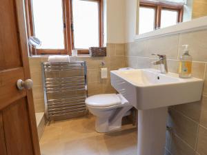 a bathroom with a white sink and a toilet at 5 Belmont Terrace in Beer +30 photos