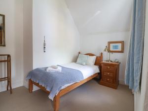 a small bedroom with a bed and a night stand at 5 Belmont Terrace in Beer