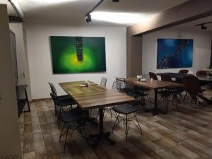 Habitación con mesas, sillas y pinturas en la pared. en The Constantine Hotel, en Estambul