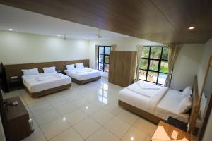 a hotel room with two beds and a window at J S Grand in Yelagiri +57 photos