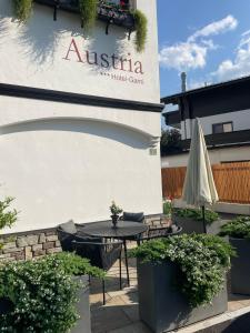 a patio with a table in front of a building at Hotel-Garni Austria Westendorf - Tirol Erleben in Westendorf +22 photos