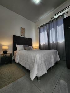 Un dormitorio con una cama grande y dos ventanas. en Casa en Residencial Nueva San Miguel, San Miguel, El Salvador, en San Miguel 14 fotos más