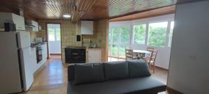 a living room with a couch and a kitchen at Casa do Outeiro de Aguil in Castro Caldelas