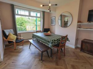 a dining room with a table and chairs and a mirror at Limhus House in Keswick