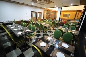 a conference room with tables and green chairs at J S Grand in Yelagiri