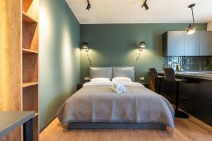 a bedroom with a bed with a desk and a kitchen at Stones Throw Apartments in Tbilisi City