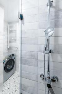 a shower stall with a washing machine in a bathroom at Stones Throw Apartments in Tbilisi City +38 photos