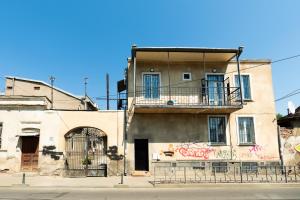 an old building with a balcony on top of it at Stones Throw Apartments in Tbilisi City