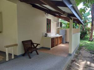 a kitchen with a chair and a sink and a refrigerator at Lake View Bungalows in Khao Lak
