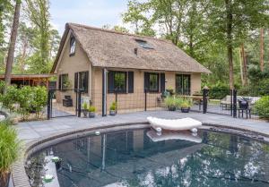 a house with a swimming pool in front of a house at Casa Black Nature in Holten