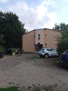 een witte auto geparkeerd voor een gebouw bij Chez Yves , 200 m du canal , 7 min de Golfech , parking privé et gratuit , rangement vélo fermés in Pommevic