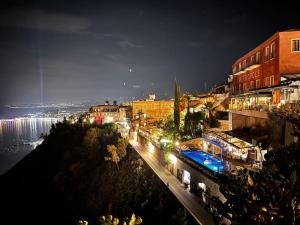 a view of a city at night with lights at MF House in Taormina