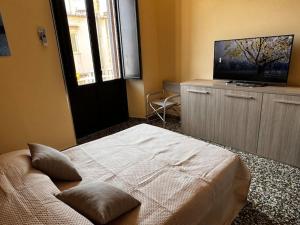 a bedroom with a bed and a flat screen tv at MF House in Taormina