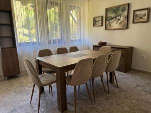 a dining room with a wooden table and chairs at Къща за гости Лъките in Divchovoto +21 photos