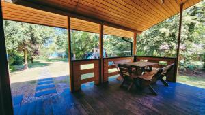 a wooden porch with a table and chairs on a deck at Chata Marzeń LUX in Wólka