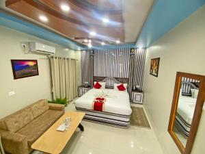 a bedroom with a bed and a couch and a mirror at Hotel Janmabhumi in Pashupatināth +179 photos