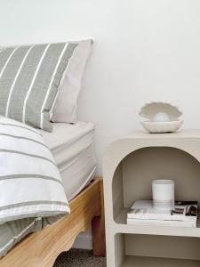 a bedroom with a bed and a shelf with a bowl on it at Villa 75 Coffin Bay in Coffin Bay