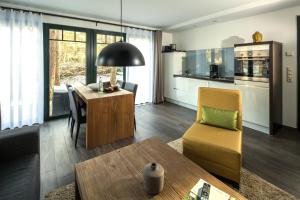 ein Wohnzimmer mit Tisch und Küche in der Unterkunft Van der Valk Naturresort Drewitz in Nossentiner Hütte