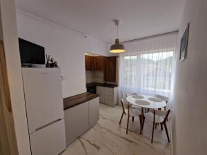 a kitchen with a small table and a white refrigerator at Apartament Marco 5 in Baia Mare